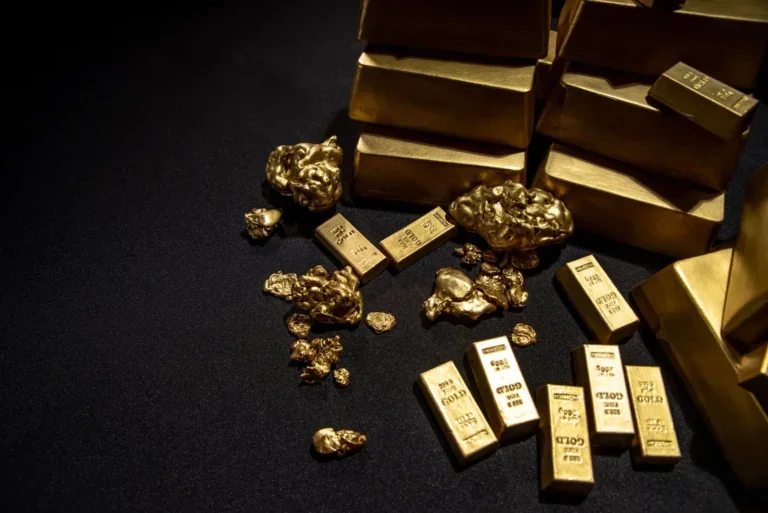 Goldbarren und Goldnuggets auf dunklem Tressen Goldankauf und Goldbarren Ankauf bei Juwelier Sascha in Wien